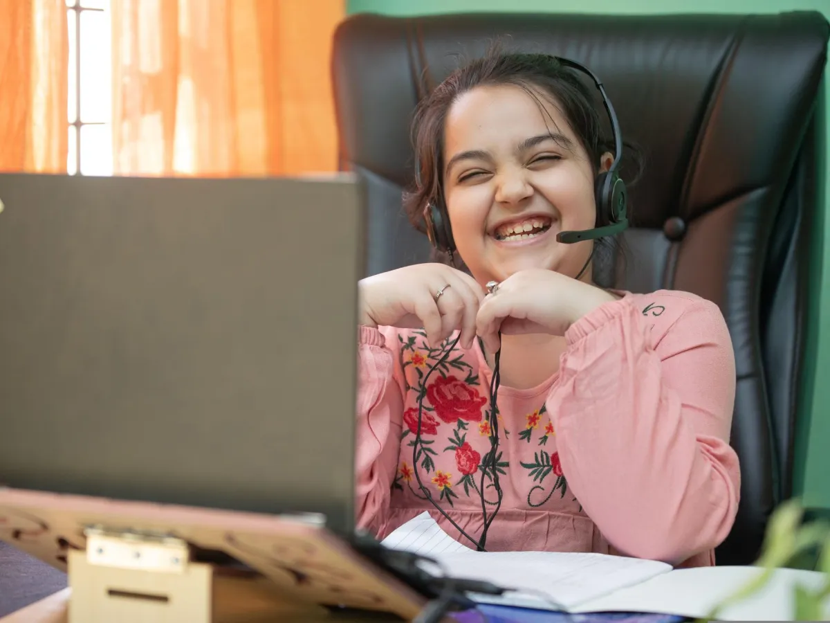 Laughing girl wearing a headset during an online live class