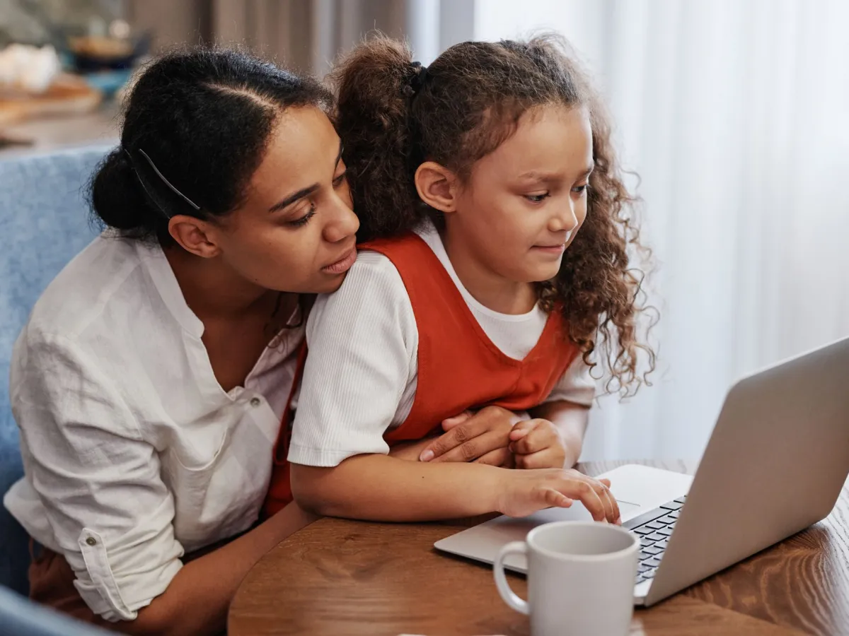 A mother and daughter exploring a program together on a laptop